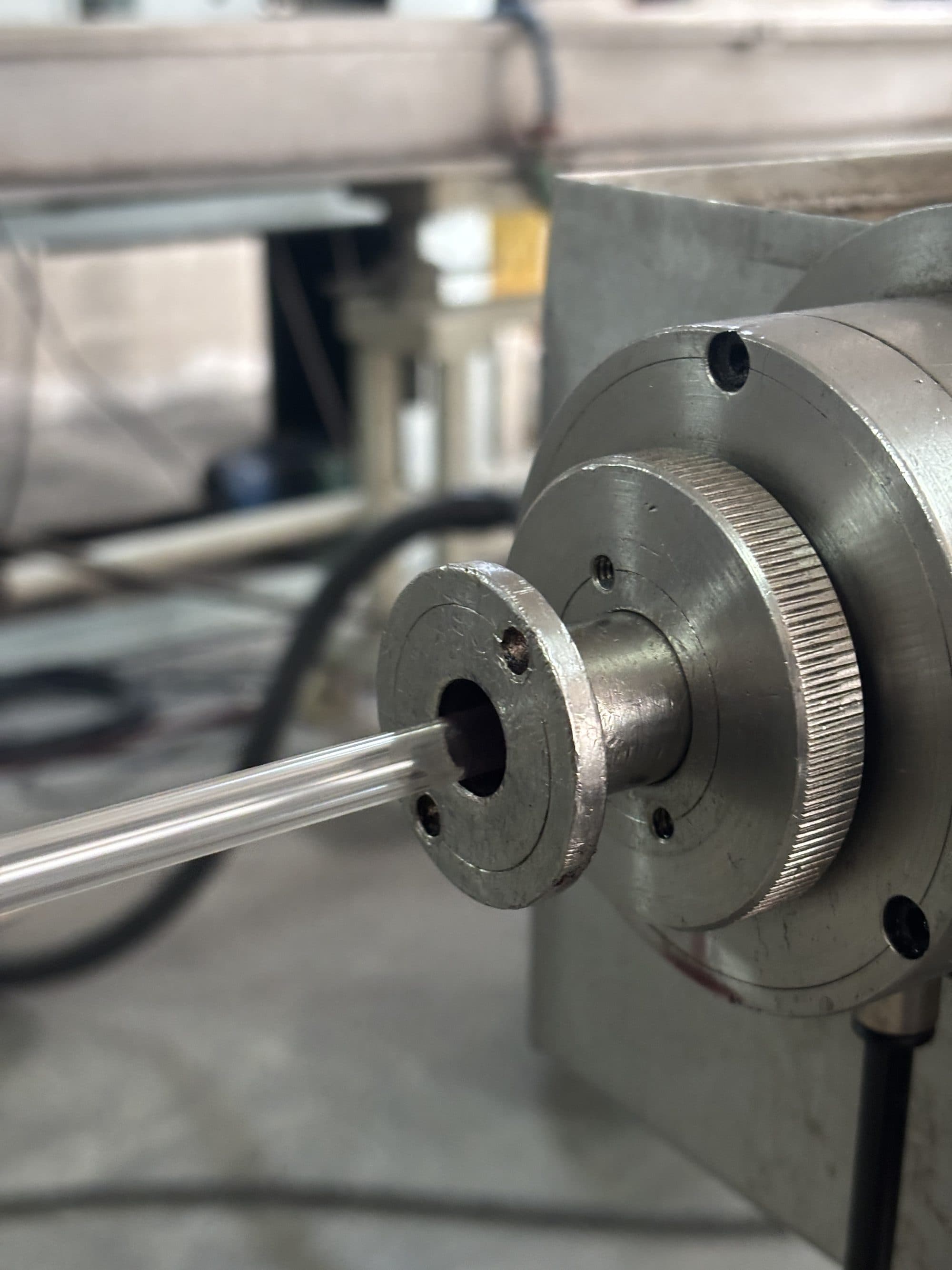 Cabezal de una máquina extrusora con un tubo de PVC saliendo